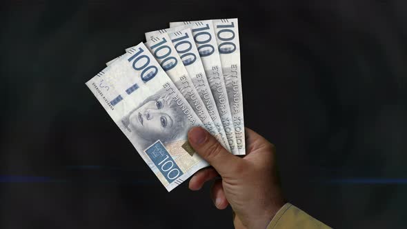 Swedish Krone money fan of banknotes in hand