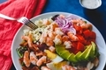 Shrimp Cobb salad with avocado, eggs, tomatoes on a plate with dressing, a colorful napkin on side - PhotoDune Item for Sale