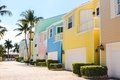 Sunny day, pastel colored apartments, houses and homes with palm trees in the background in Florida - PhotoDune Item for Sale