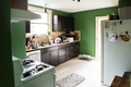 Green painted kitchen in newly moved into home with brown cabinets and oven - PhotoDune Item for Sale
