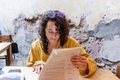 Candid of Millennial Woman with curly hair looking at a menu at a restaurant - PhotoDune Item for Sale