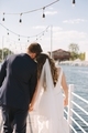 Bride and groom at a summer wedding pier on the water leaning their heads together  - PhotoDune Item for Sale