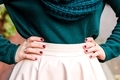 Woman putting her hands on her hips with fashionable outfit, green sweater and painted nails - PhotoDune Item for Sale