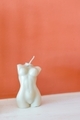 Minimalistic woman female body figure white candle on a white surface with terracotta background - PhotoDune Item for Sale