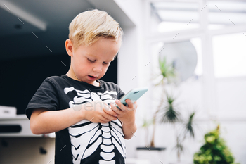 Little boy with smart phone in living room