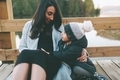 A mother and son sitting together and talking on a bridge outside.  - PhotoDune Item for Sale