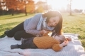 A grandmother playing with her grandchild on a blanket in the park.  - PhotoDune Item for Sale