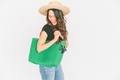A happy woman carrying a bright green bag against a plain white background.  - PhotoDune Item for Sale