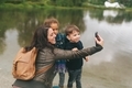 A woman taking selfie’s with two young children in the park.  - PhotoDune Item for Sale
