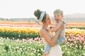 A mother holding a laughing little boy in a field of tulips in the spring.  - PhotoDune Item for Sale