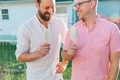 Two men laughing and enjoying ice cream bars in the backyard in summertime. - PhotoDune Item for Sale