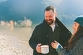 A couple laughing together in cozy sweaters at the lake.  - PhotoDune Item for Sale