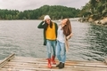 Two women friends laughing together at the end of a dock on the ocean or lake.  - PhotoDune Item for Sale