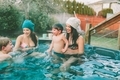 Two happy women and their children sitting in a backyard hot tub.  - PhotoDune Item for Sale