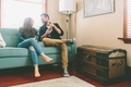 A happy couple sitting on a couch at home having a drink.   - PhotoDune Item for Sale