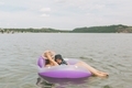 A mother and baby relaxing in an inner tube floaty on a lake. - PhotoDune Item for Sale