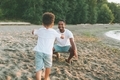 A little boy running into his father's arms at the beach. - PhotoDune Item for Sale
