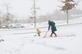 A mother an son shovelling snow in the driveway.  - PhotoDune Item for Sale