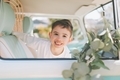 A happy little boy smiling  in the window of a retro camper van. - PhotoDune Item for Sale