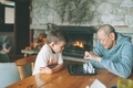 A grandfather and grand son playing chess together. - PhotoDune Item for Sale