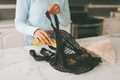 A woman pulling groceries out of a sustainable, eco-friendly reusable bag while in the kitchen. - PhotoDune Item for Sale