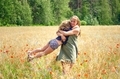 a young woman is circling a child in her arms on a blooming field,  - PhotoDune Item for Sale
