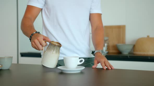 A Middle Shot of a Young Man Pouring Coffee Into the Cup Early Morning Coffee Making