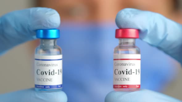 Doctor Holds Two Different Covid Coronavirus Vaccine Vials in Hands