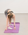 young slim woman wearing top and leggings doing bends on a yoga mat.  - PhotoDune Item for Sale