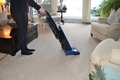 Woman vacuuming the carpet in the living room at home - PhotoDune Item for Sale