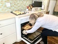 Women in the kitchen taking hot lasagna out of oven for dinner  - PhotoDune Item for Sale