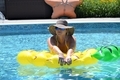 Sexy woman wearing hat and sunglasses floating in swimming pool  - PhotoDune Item for Sale