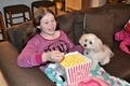 Young girl at home watching television with her cute pet eating popcorn - PhotoDune Item for Sale