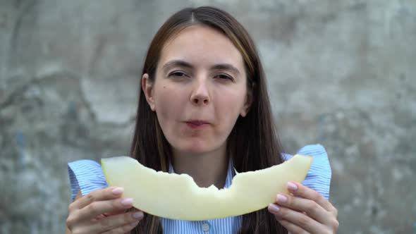 Portrait of a Beautiful Young Woman Eating Melon