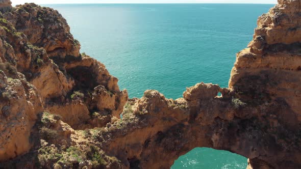 Fly-over 'Catedral' Stone Arch in Lagos, revealing Algarve Coastal sea, Portugal