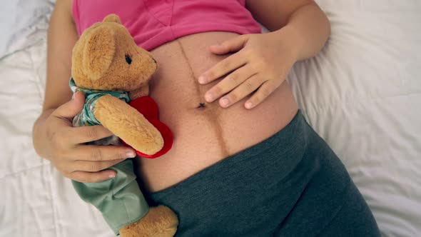 Happy Pregnant Woman Sleeping on Bed in Bedroom