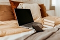 laptop on cozy bed with books in bedroom - PhotoDune Item for Sale