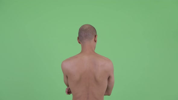 Rear View of Bald Multi Ethnic Shirtless Man Pointing Finger