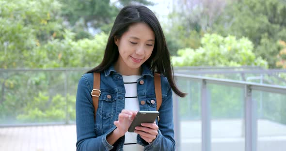 Woman use of smart phone and walking in the street