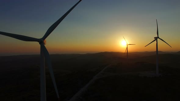 Close up aerial view of windmill blades at sunset