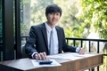 Young Asian businessman financial market analyst sits at their desks and calculate financial graphs  - PhotoDune Item for Sale