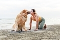 Asian young woman kisses her dog during doing yoga on a yoga mat on the beach. Relaxation with a pet - PhotoDune Item for Sale