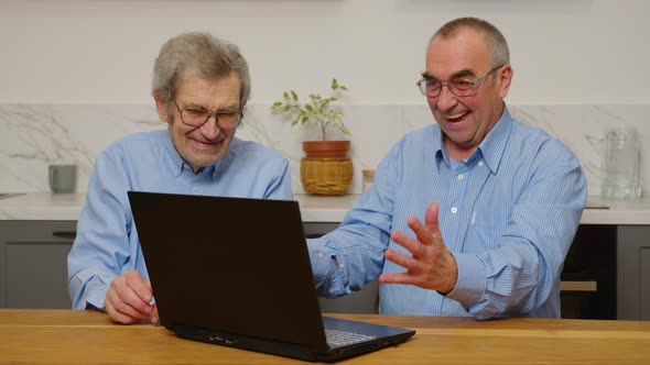 Senior Mature Older Mans Using a Laptop While Relaxing at Home