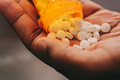 African American man pouring pills into hand prescription drug concept  - PhotoDune Item for Sale