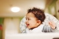 Curly hair mixed race or biracial baby at home in high chair getting ready to eat fold big smile  - PhotoDune Item for Sale