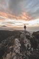 Young man in the top of the mountain enjoying the cloudy sunset and the rocky landscape  - PhotoDune Item for Sale