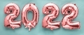 2022 new year pink foil balloon numbers on green background - PhotoDune Item for Sale
