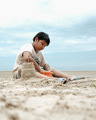 A boy build sand castle at the beach - PhotoDune Item for Sale