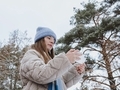 Girl in winter weather in a gray coat uses the phone and social networks - PhotoDune Item for Sale