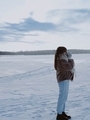 Stylish girl warms her hands on the background of a frozen lake - PhotoDune Item for Sale